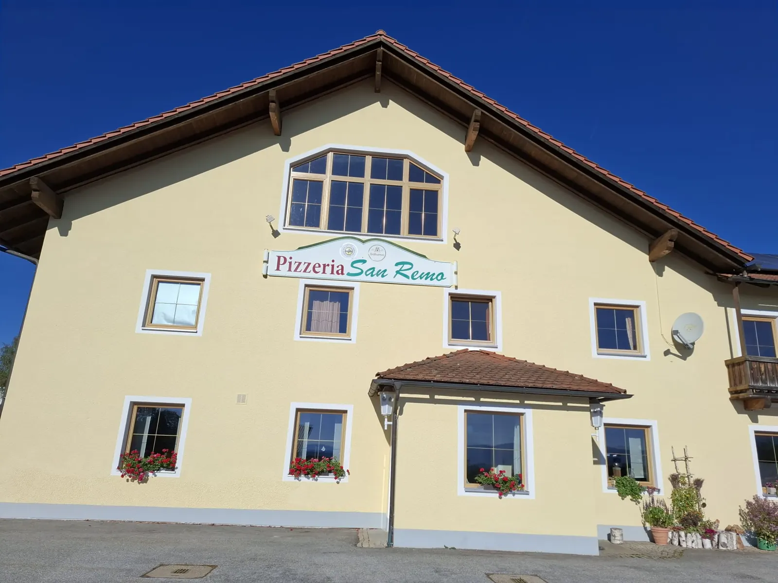 Hausfassade mit dem Schild der Pizzeria San Remo